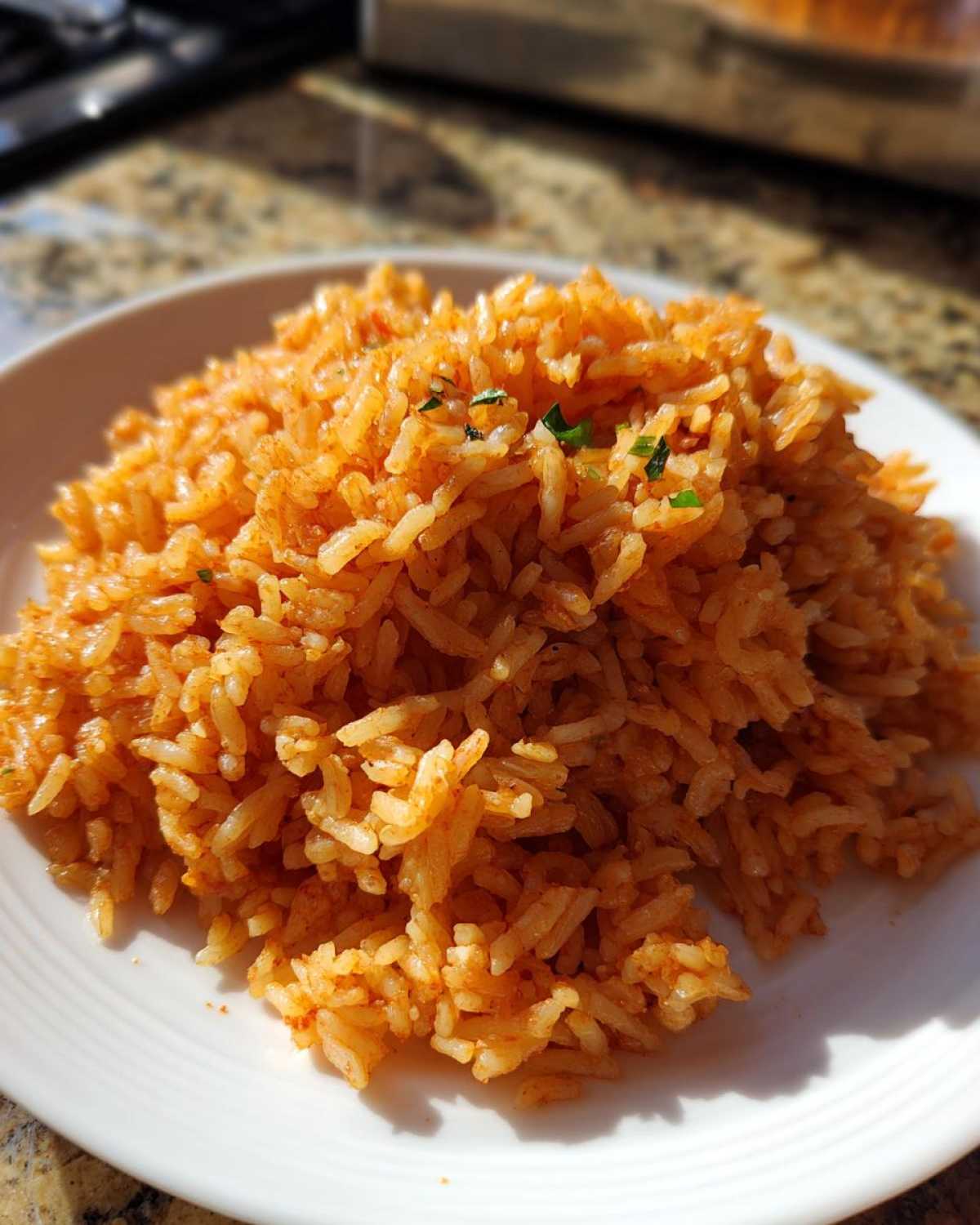 A close-up of fluffy Mexican rice, perfectly cooked and seasoned, served on a white plate.