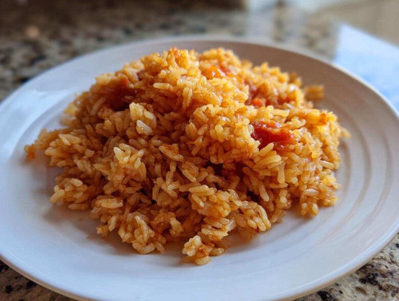 A close-up of a mound of Simple & Fluffy Mexican Rice on a white plate.