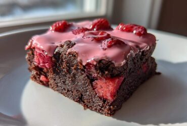 A single, rich slice of Strawberry Brownies with Sweet Strawberry Glaze, topped with fresh strawberries.