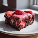 A rich, fudgy slice of Strawberry Brownies with Sweet Strawberry Glaze, topped with fresh strawberries.