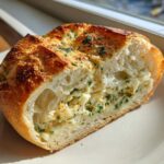 A cross-section of Swirled Garlic Herb and Cheese Bread showing the fluffy interior and cheesy filling.