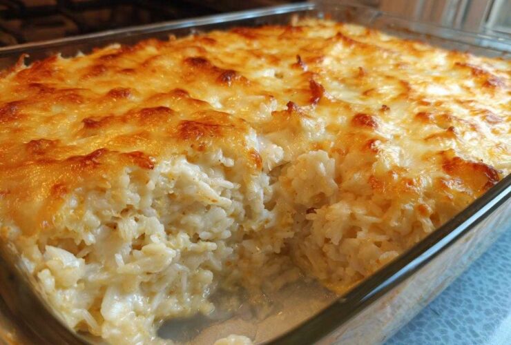 Close-up of a baked Chicken Cauliflower Rice Casserole with a golden, melted cheese topping in a glass dish.