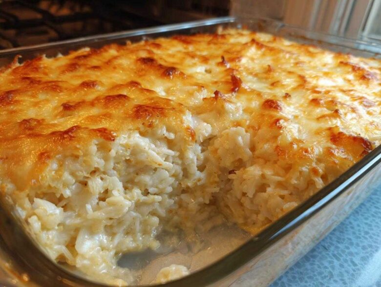 Close-up of a baked Chicken Cauliflower Rice Casserole with a golden, melted cheese topping in a glass dish.