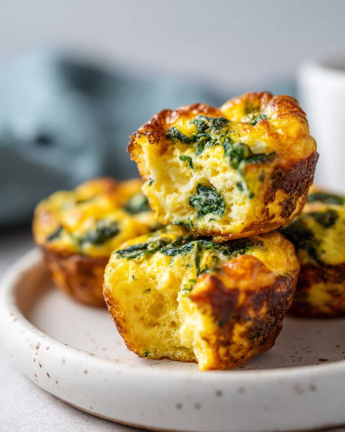 Close-up of fluffy Egg Bites With Cottage Cheese and spinach, with one bite taken out.