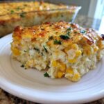 A slice of creamy Mexican Street Corn Casserole loaded with corn kernels and topped with melted cheese and herbs.