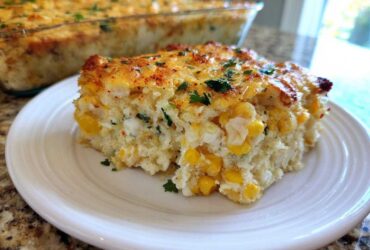 A slice of creamy Mexican Street Corn Casserole loaded with corn kernels and topped with melted cheese and herbs.
