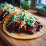 A close-up of a delicious Mushroom Tacos served on a corn tortilla, topped with rich filling and fresh coleslaw.