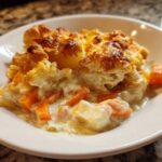 A close-up serving of Rich Winter Vegetable Casserole, showing creamy sauce, carrots, and a golden, cheesy baked topping.