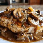 Close-up of a juicy chicken breast topped with rich mushroom gravy, resembling Texas Roadhouse Smothered Chicken.