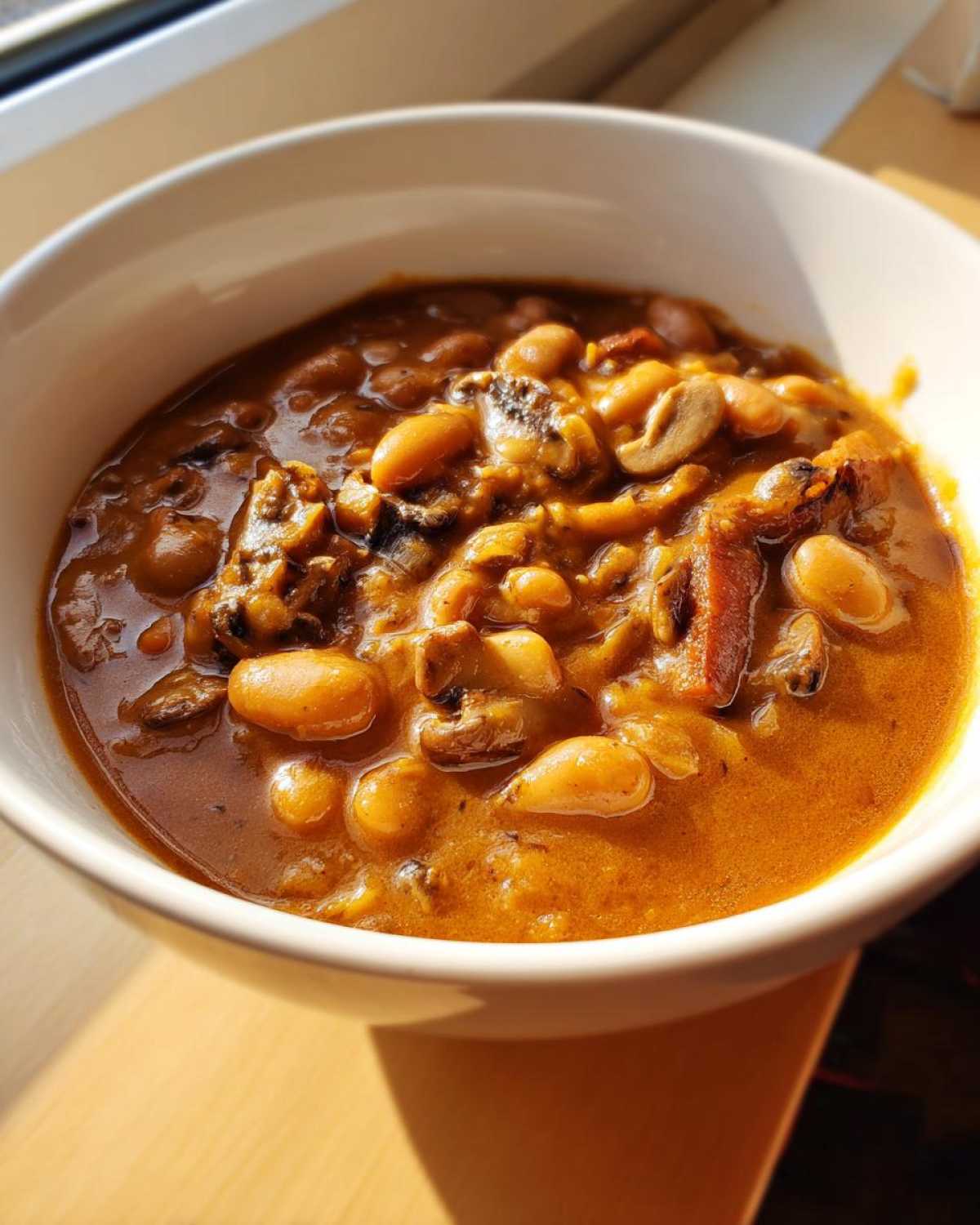 Close-up of a hearty bowl of Vegan Stew with White Beans and Mushrooms in a rich, savory broth.