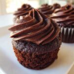 Close-up of a rich, dark chocolate cupcake topped with a perfectly piped swirl of Chocolate Cupcakes Frosting.