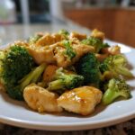 A close-up shot of tender chicken pieces coated in a glossy sauce mixed with bright green broccoli florets, representing Garlic Butter Chicken and Broccoli.