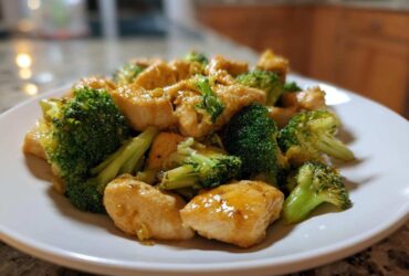 A close-up shot of tender chicken pieces coated in a glossy sauce mixed with bright green broccoli florets, representing Garlic Butter Chicken and Broccoli.