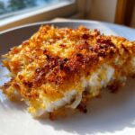Close-up of a flaky white fish fillet topped with a crispy, golden-brown Keto Butter Parmesan Crusted Cod topping.